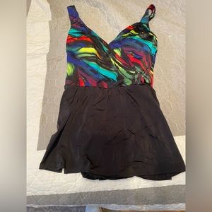 Ladies swimsuit multi colored with black bottom has attached skirt